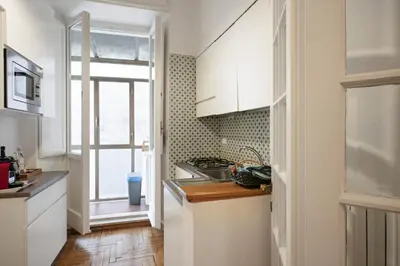 a kitchen with white cabinets and a sink and a window at Trevi Fountain Apartment in Rome
