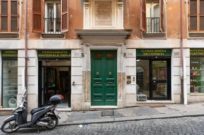 a scooter parked in front of a building with a green door at GuestHost - Basic Studio - 350 m far from Fontana di Trevi in Rome