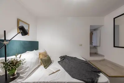 a living room with a white couch and a lamp at GuestHost - Basic Studio - 350 m far from Fontana di Trevi in Rome
