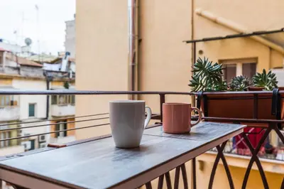two coffee cups sitting on a table on a balcony at Minerva's Place in Rome