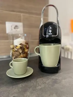a coffee maker and two cups on a counter at La Casa di Marco Polo in Rome