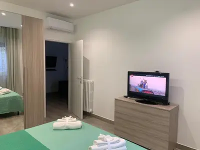 a living room with a television and two pairs of shoes at La Casa di Marco Polo in Rome