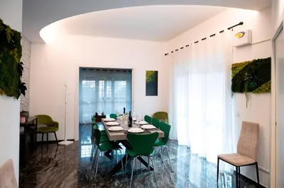 a dining room with a table and green chairs at Home Big Crirè at 724 in Rome