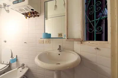 a white bathroom with a sink and a mirror at Vivaldi in Rome