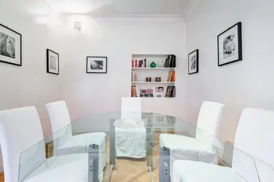 a dining room with a glass table and white chairs at Pantheon Exclusive House in Rome
