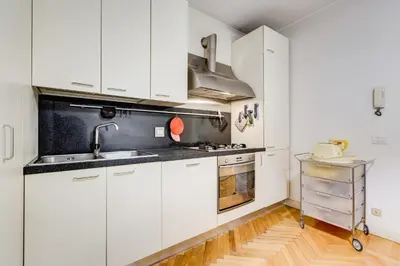 a white kitchen with white cabinets and a sink at Pantheon Exclusive House in Rome