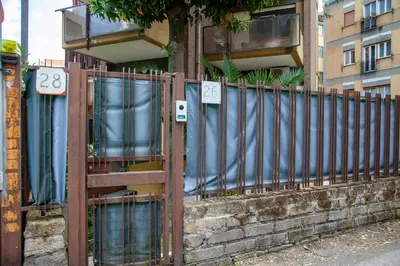 a fence in front of a building with numbers on it at Garden City House Roma - Casa con giardino privato in Rome