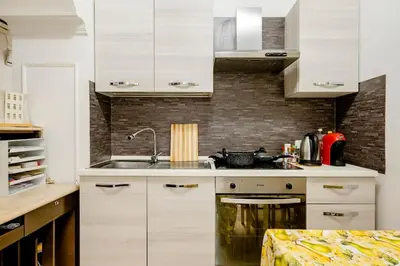 a kitchen with white cabinets and a sink at Francesco Romestay - Termini in Rome