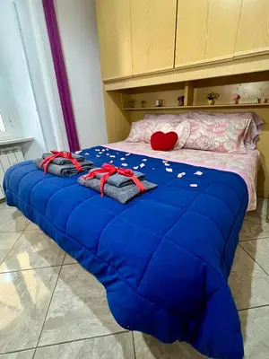 a bed with a blue blanket on top of it at Monolocale San Giovanni in Rome