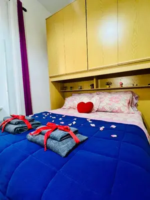 a bed with a blue blanket with a red heart on it at Monolocale San Giovanni in Rome