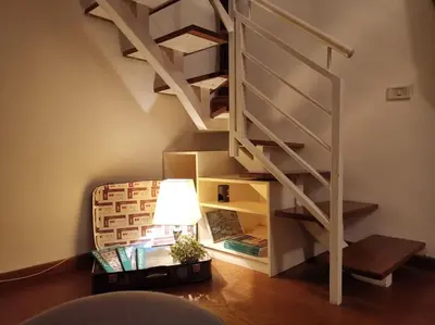 a living room with a spiral stair with a lamp at La Dimora Dante in Rome