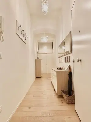 a hallway with white walls and a wooden floor at Ovidio Luxury in Rome