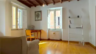 a living room with a couch and a table and windows at San Martino Home in Rome