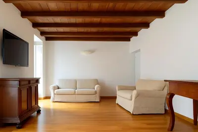 a living room with two chairs and a flat screen tv at San Martino Home in Rome