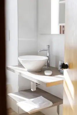 a bathroom with a white bowl sink on a counter at 