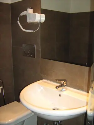 a bathroom with a sink and a mirror and a toilet at Appia Nuova Holiday B&B in Rome
