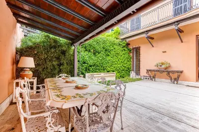 a patio with a table and chairs on a deck at BMGA l Luxury Home with Patio in Trastevere in Rome