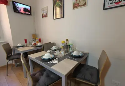 a dining room with two tables and chairs at Aria Rome Rooms in Rome