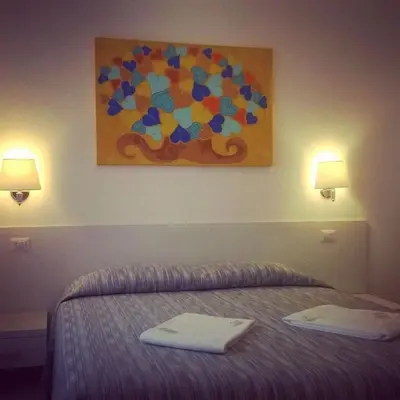 a bedroom with a bed with a painting on the wall at Buonarroti Guest House in Rome