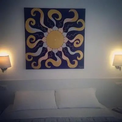 a painting on a wall above a bed in a room at Buonarroti Guest House in Rome