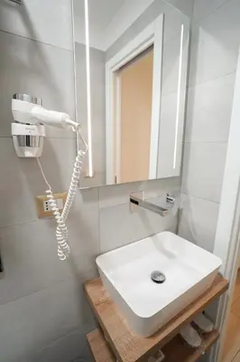 a bathroom with a white sink and a mirror at Charm&Bella GuestHouse in Rome