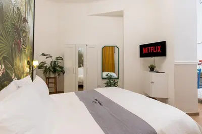 a bedroom with a large white bed and a tv at Rhome_Hub in Rome
