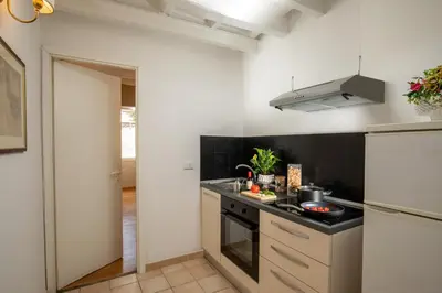 a kitchen with white walls and a black counter top at Daplace - Arianna Apartment in Rome