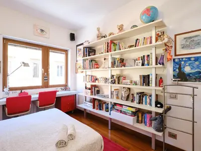 a bedroom with a book shelf filled with books at Marisol's House, Colosseo in Rome