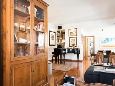 a living room with a large wooden cabinet and a piano at Marisol's House, Colosseo in Rome