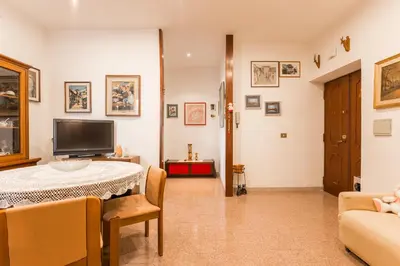 a living room with a table and a tv at family home in Rome