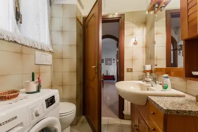 a bathroom with a sink and a washing machine at family home in Rome
