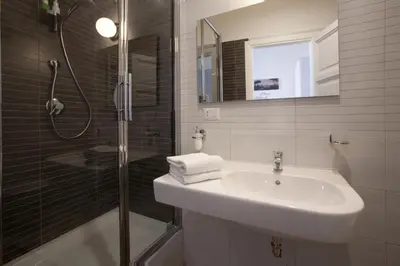 a white bathroom with a sink and a shower at Saint Peter's Keys in Rome