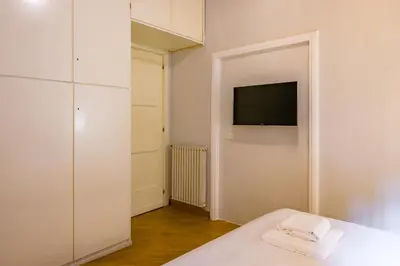 a bedroom with a bed and a tv on a wall at CasAlice Apartment Trastevere in Rome