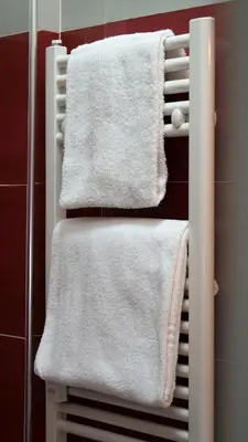 a towel rack with white towels on it in a bathroom at Tiburtina Royal Suites in Rome