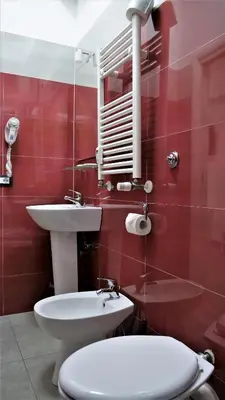 a red bathroom with a toilet and a sink at Tiburtina Royal Suites in Rome