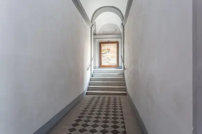 a hallway with a checkered floor and a window at Trastevere San Calisto 3 BDR Apartment in Rome