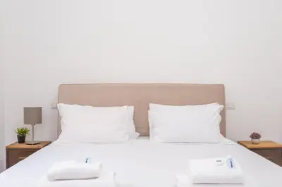 a white bed with two white towels on it at Trastevere San Calisto 3 BDR Apartment in Rome