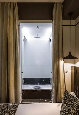 a bedroom with a glass door leading to a shower at Corso 281 Luxury Suites in Rome