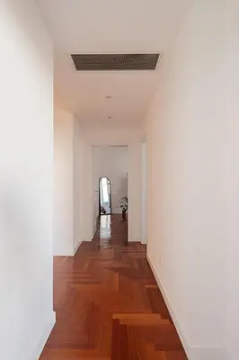 an empty hallway with white walls and wood floors at Lunaria Apartment Vatican Rome in Rome