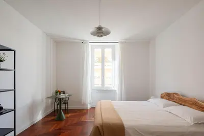 a white bedroom with a bed and a window at Lunaria Apartment Vatican Rome in Rome