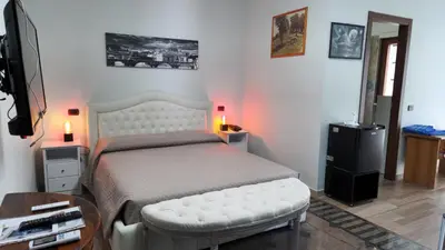 a bedroom with a white bed and a table at Castelbarco House B in Rome