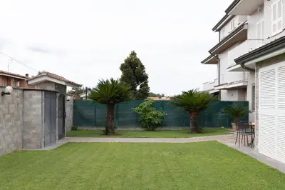 a backyard with a fence and palm trees at Castelbarco House A in Rome
