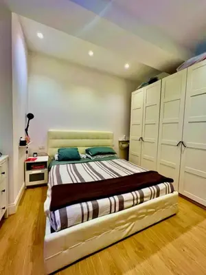 a bedroom with a large bed with white cabinets at Auditorium luxury suite Roma in Rome
