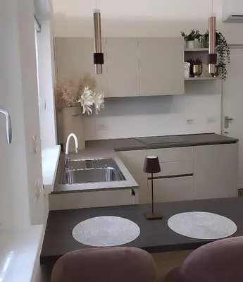 a kitchen with white cabinets and a sink and a counter at Buongiorno al Vaticano in Rome