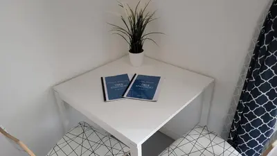 a table with two books and a potted plant on it at Tiber Apartment in Trastevere in Rome