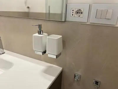 a bathroom with two soap dispensers on a wall at Colosseum Rome Guest House Luil in Rome
