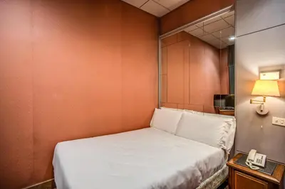 a bed in a room with a mirror and a phone at Castro Pretorio 64 Easy Rooms in Rome