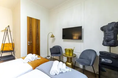 a bedroom with a bed and two chairs and a tv at Best Room Catone 21 in Rome