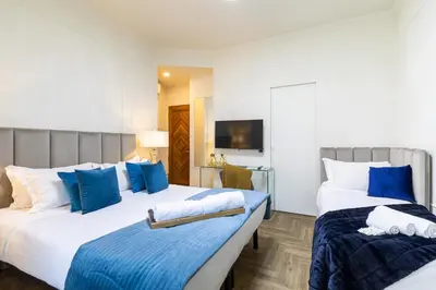 two beds in a hotel room with blue pillows at Best Room Catone 21 in Rome