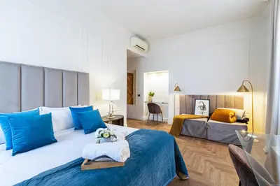 a bedroom with two beds with blue pillows at Best Room Catone 21 in Rome